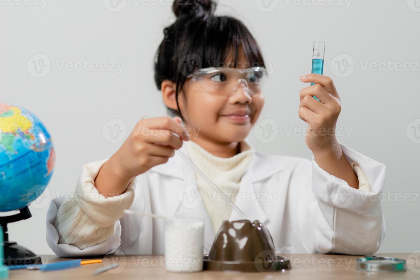 education, science, chemistry and children concept - kids or students with test tube making experiment at school laboratory photo