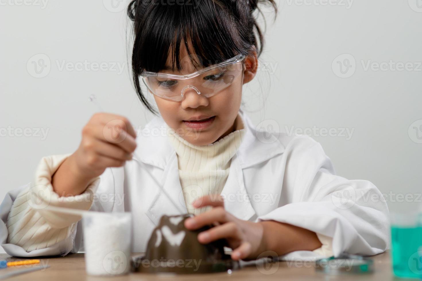 education, science, chemistry and children concept - kids or students with test tube making experiment at school laboratory photo