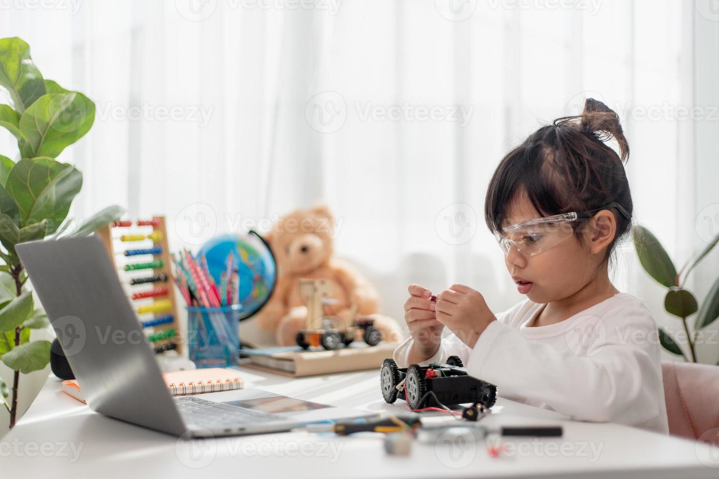 Asia students learn at home in coding robot cars and electronic board cables in STEM, STEAM, mathematics engineering science technology computer code in robotics for kids concept. photo