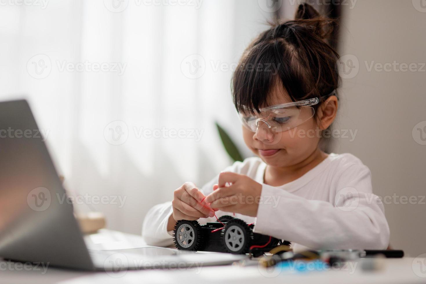 Asia students learn at home in coding robot cars and electronic board cables in STEM, STEAM, mathematics engineering science technology computer code in robotics for kids concept. photo
