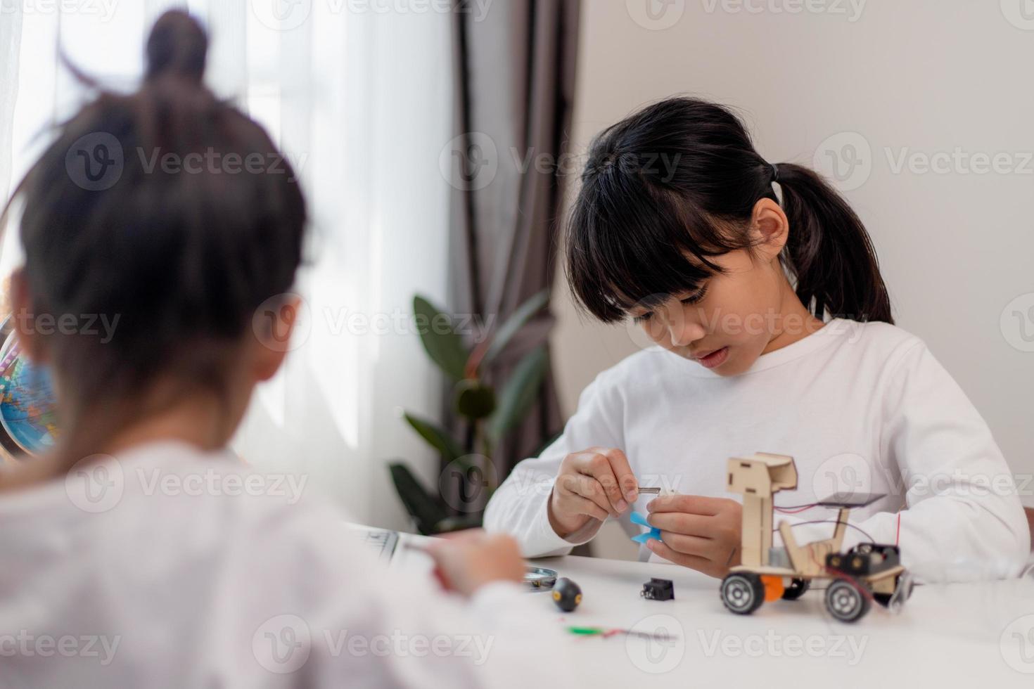 Asia students learn at home in coding robot cars and electronic board cables in STEM, STEAM, mathematics engineering science technology computer code in robotics for kids concept. photo