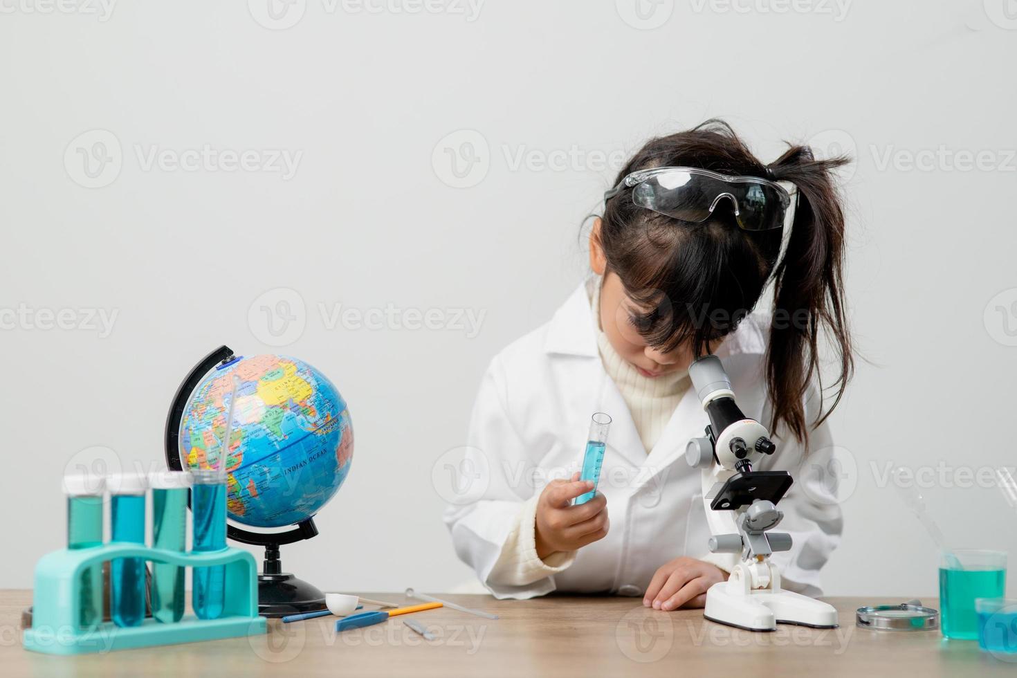 education, science, chemistry and children concept - kids or students with test tube making experiment at school laboratory photo