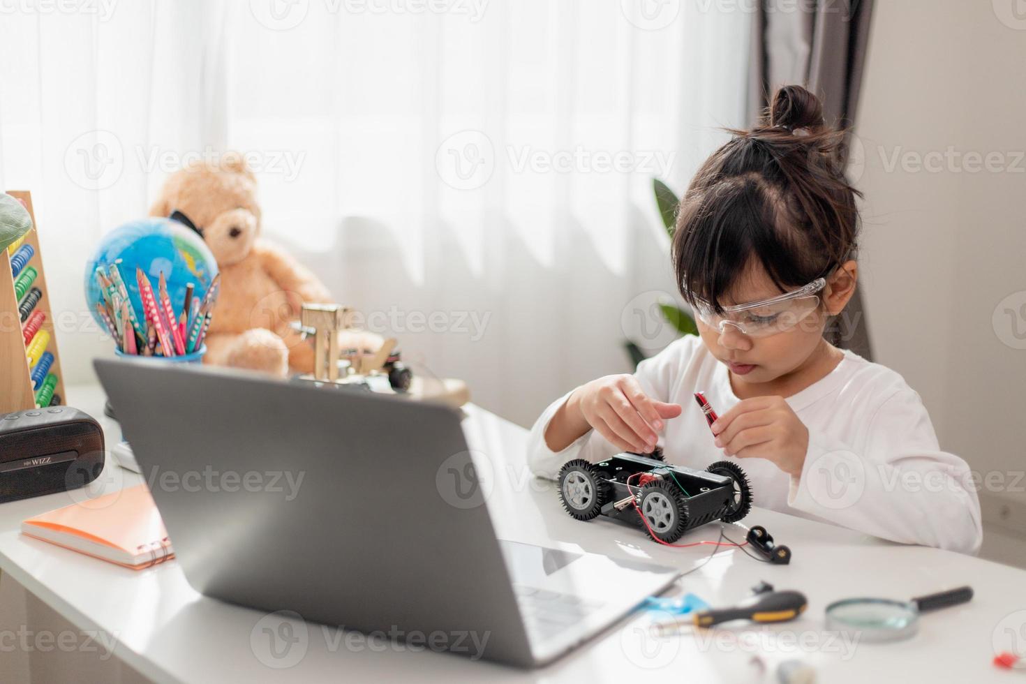 Asia students learn at home in coding robot cars and electronic board cables in STEM, STEAM, mathematics engineering science technology computer code in robotics for kids concept. photo