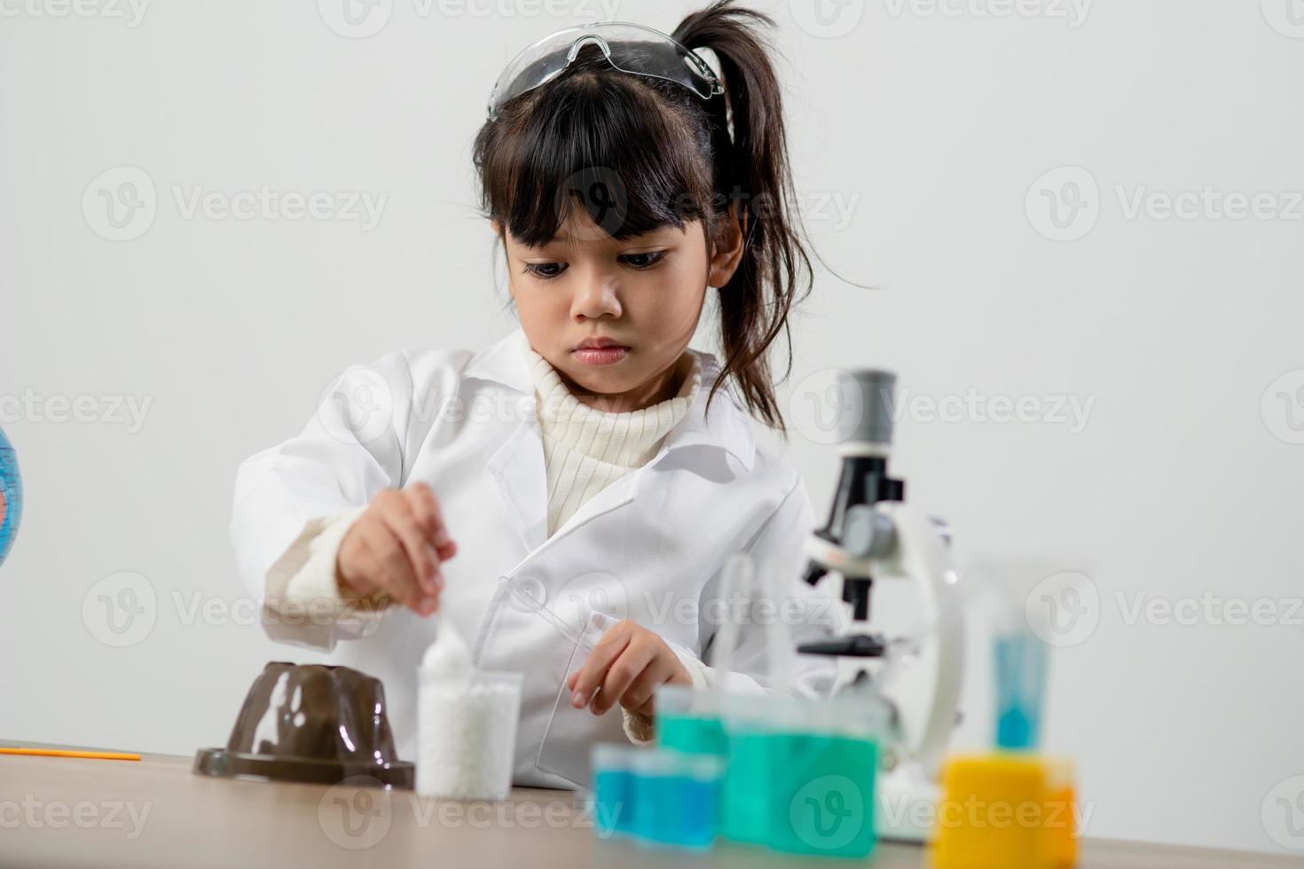 education, science, chemistry and children concept - kids or students with test tube making experiment at school laboratory photo