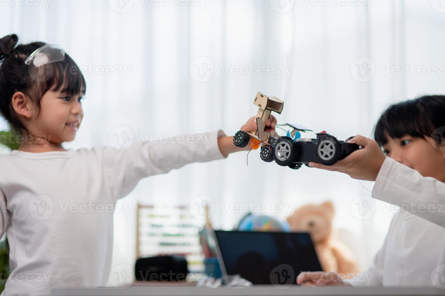 Asia students learn at home in coding robot cars and electronic board cables in STEM, STEAM, mathematics engineering science technology computer code in robotics for kids concept. photo