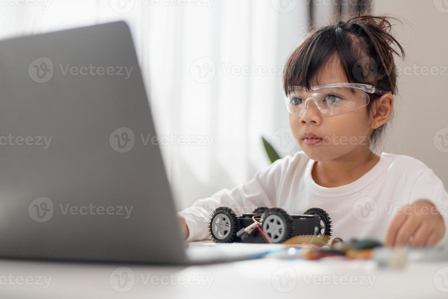 Asia students learn at home in coding robot cars and electronic board cables in STEM, STEAM, mathematics engineering science technology computer code in robotics for kids concept. photo