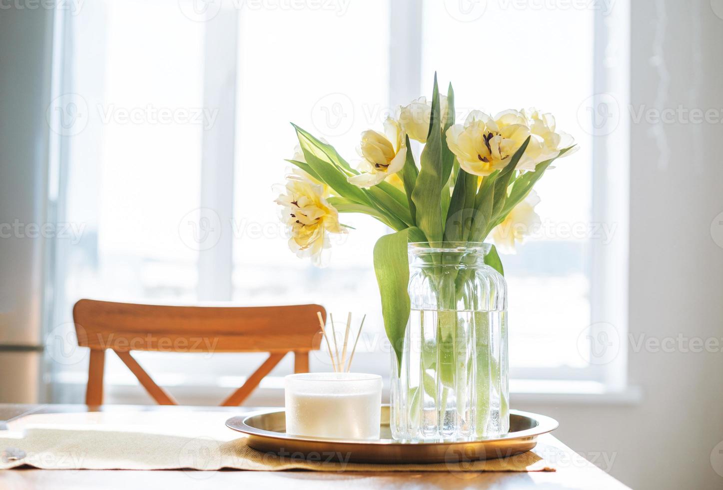https://static.vecteezy.com/system/resources/previews/016/691/481/non_2x/beautiful-bouquet-of-yellow-tulips-in-vase-on-dinner-table-in-white-kitchen-light-interior-at-home-photo.jpg