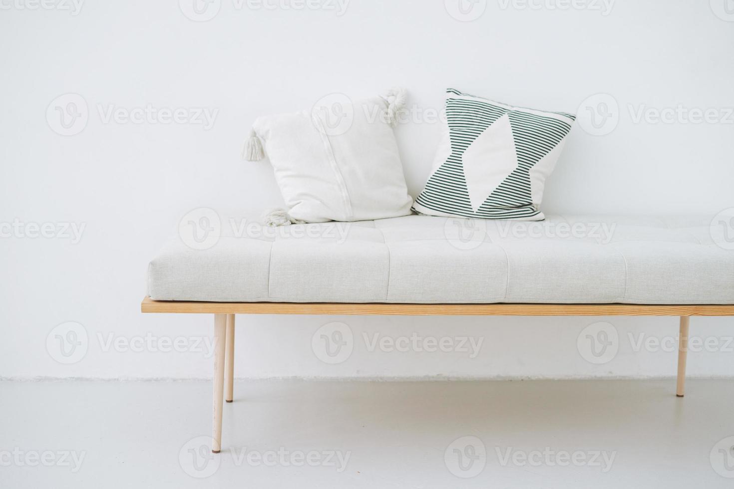 Minimalistic wooden bench with linen pillows in eco-style on white wall background photo