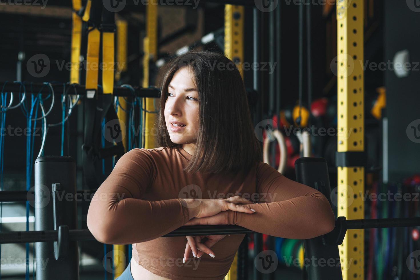 retrato de una joven morena con ropa deportiva activa en el gimnasio del club de fitness foto