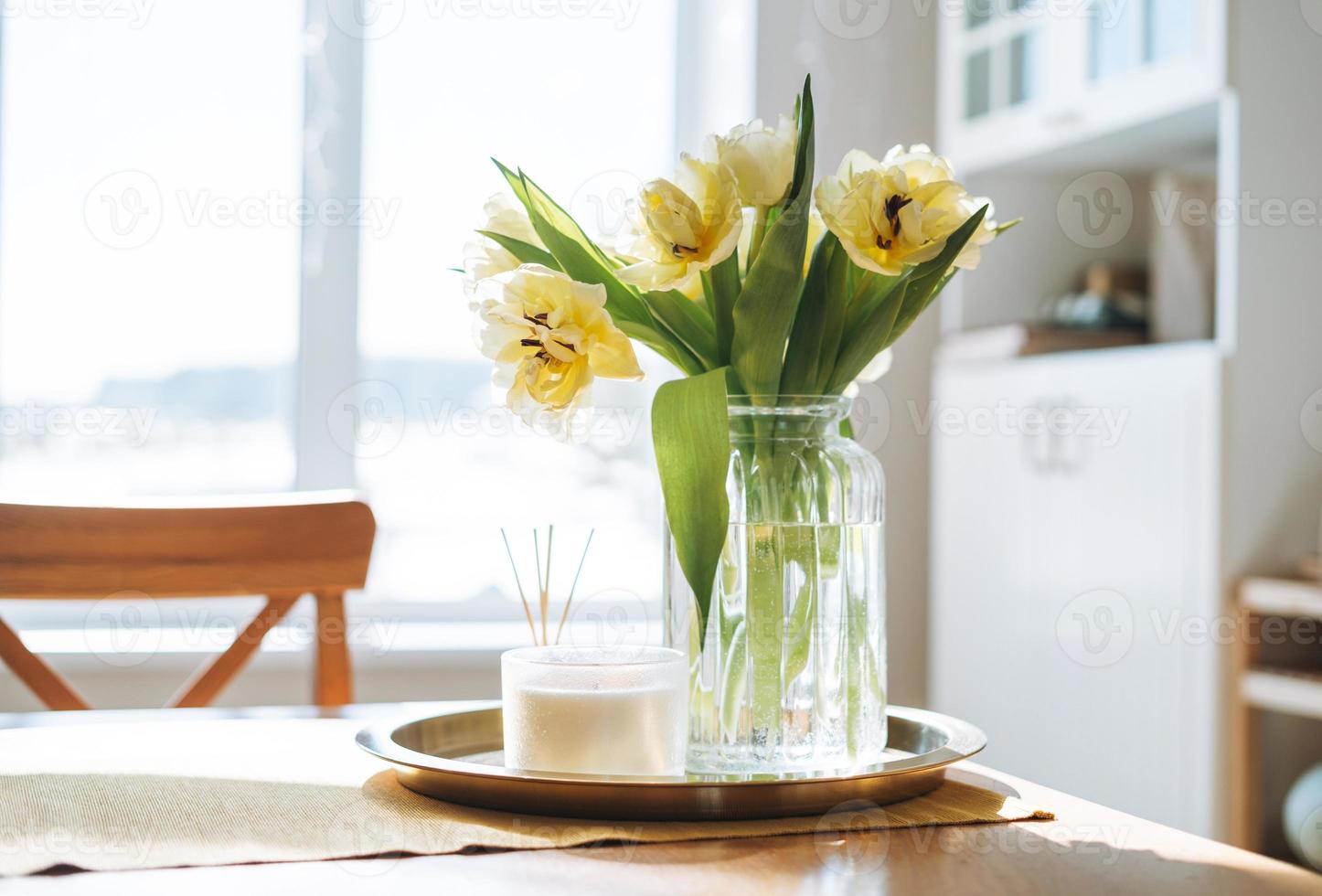 Vases with Beautiful Flowers on Table in Kitchen Interior. Stock