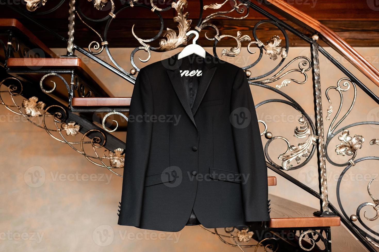 Stylish elegant black wedding groom suit hanging on a hanger. Preparations on the wedding morning. photo