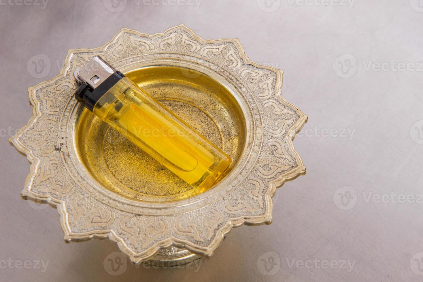 Lighter on the golden try for lighting incense sticks and praying in temple photo