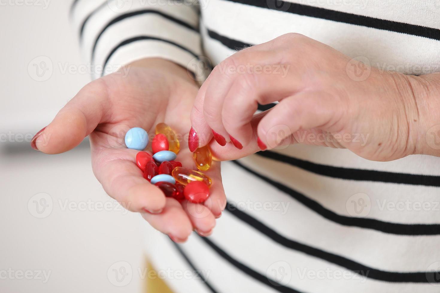 Close-up image of senior womans hand holding capsules of pills, medicine and recovery treatment, copy space. Photo of a elderly woman taking daily medicine. Healthcare concept.