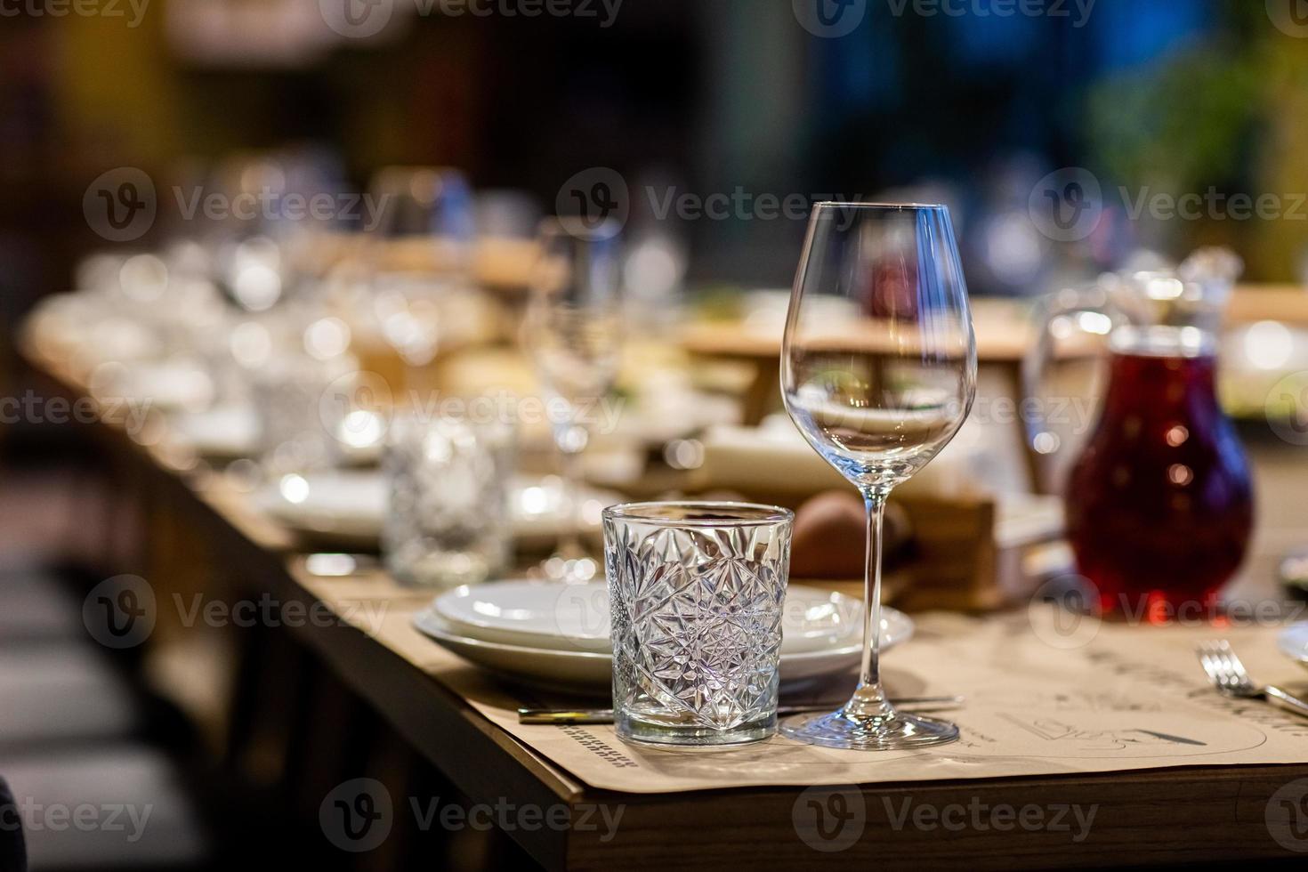 Tables set for an event party or wedding reception. luxury elegant table setting dinner in a restaurant. glasses and dishes. Empty glasses set in restaurant. Part of interior photo