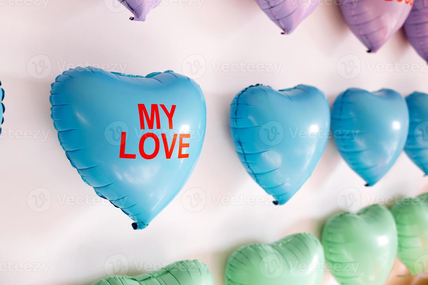 background of colorful balloons in the shape of heart. Love concept. Holiday Object, Birthday, Valentines Day, Wedding. Party decoration. Greeting card. heart with inscriptions kiss me photo