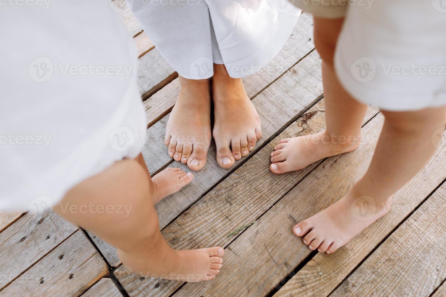 familia de tres. madre y dos niños jugando afuera. piernas de personas irreconocibles. familia feliz de pie al aire libre en un cálido día de verano. concepto de familia. gente de vacaciones disfrutando de la naturaleza foto