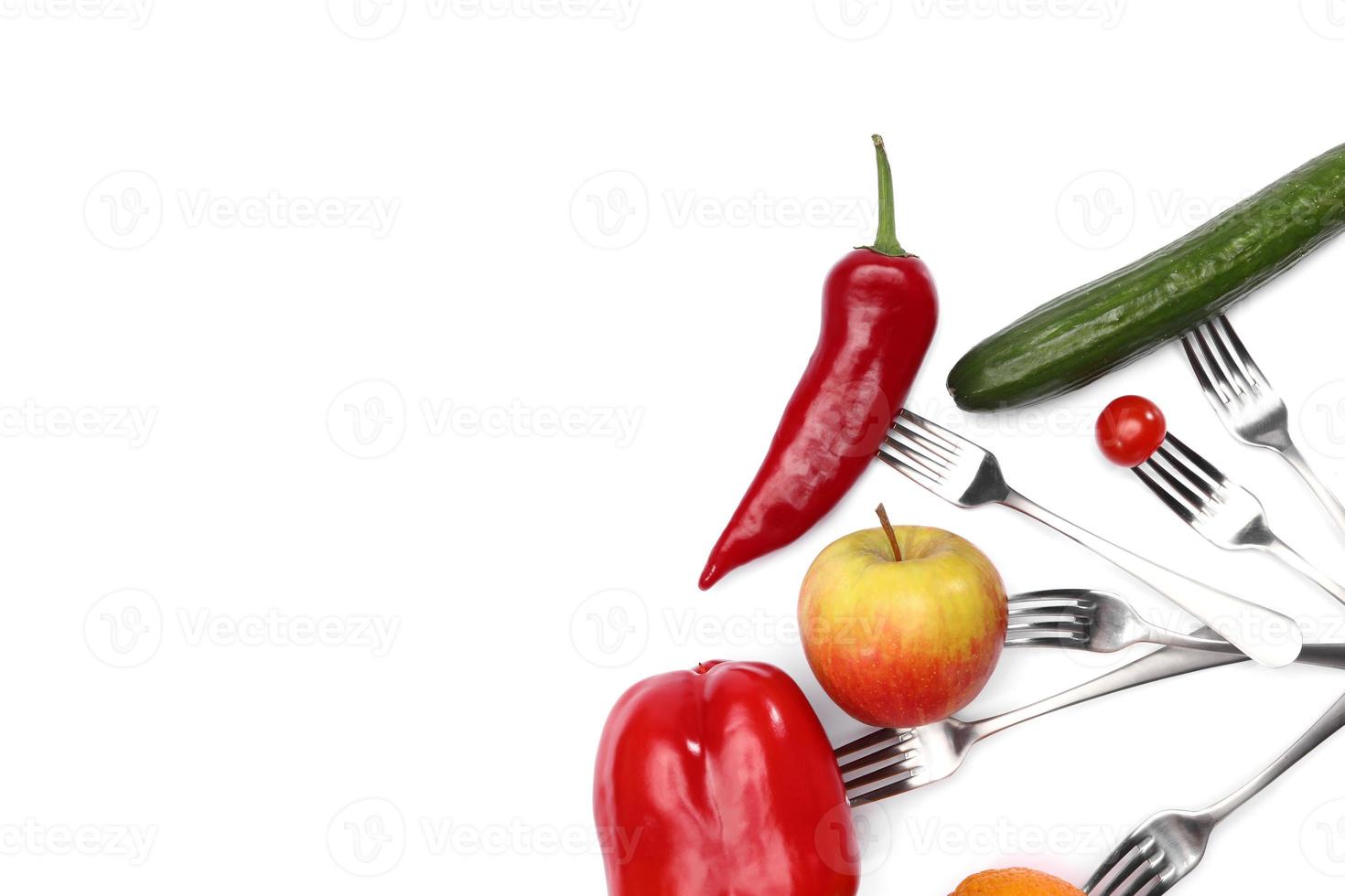 A healthy diet food. fresh cherry tomato, red pepper, cucumber, apple and orange fruits on forks on white background. Healthy eating and vegetarian food, cooking concept. photo