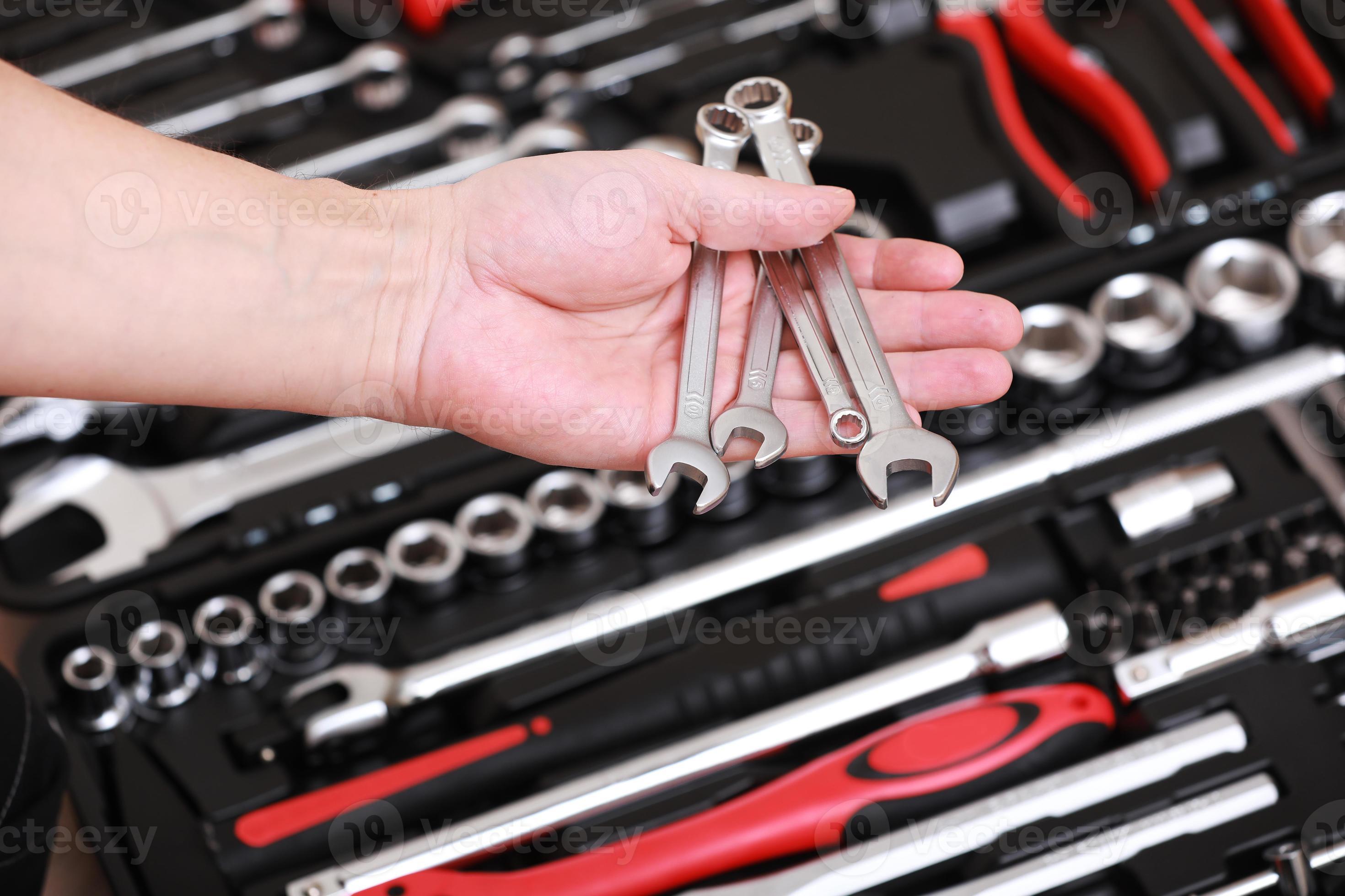 Tool store. Closeup of male hand holding wrenches. Auto repair kit in