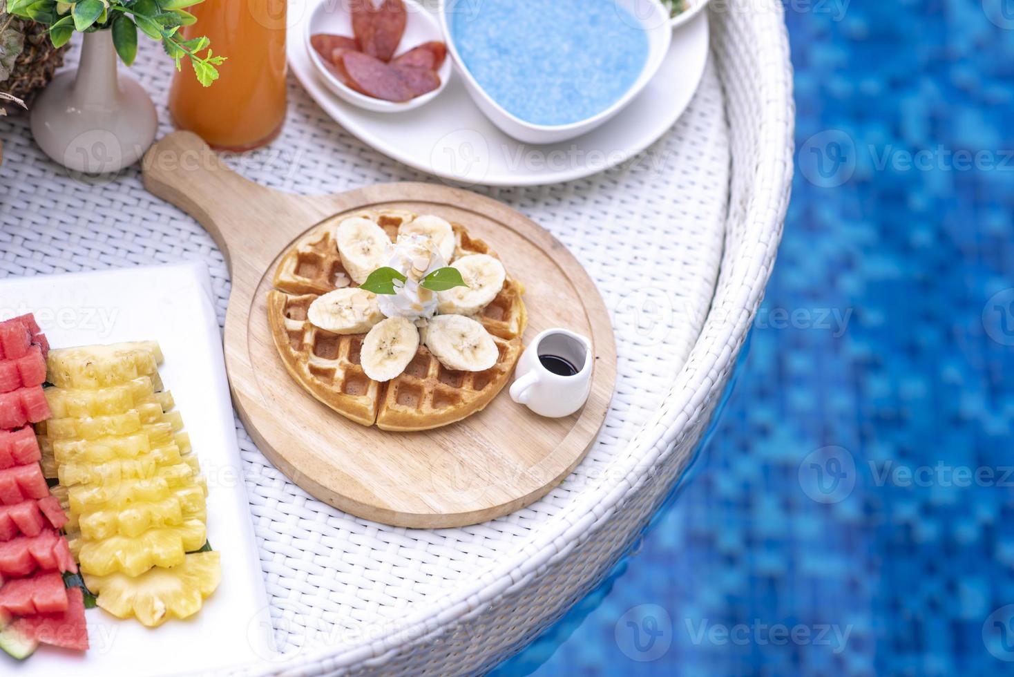 desayuno en piscina, desayuno flotante en villa resort. relajarse en el agua tranquila de la piscina, desayuno saludable y frutas tropicales. foto