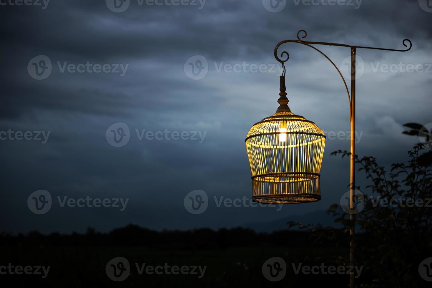 White bird cage as Lamp against dark sky photo