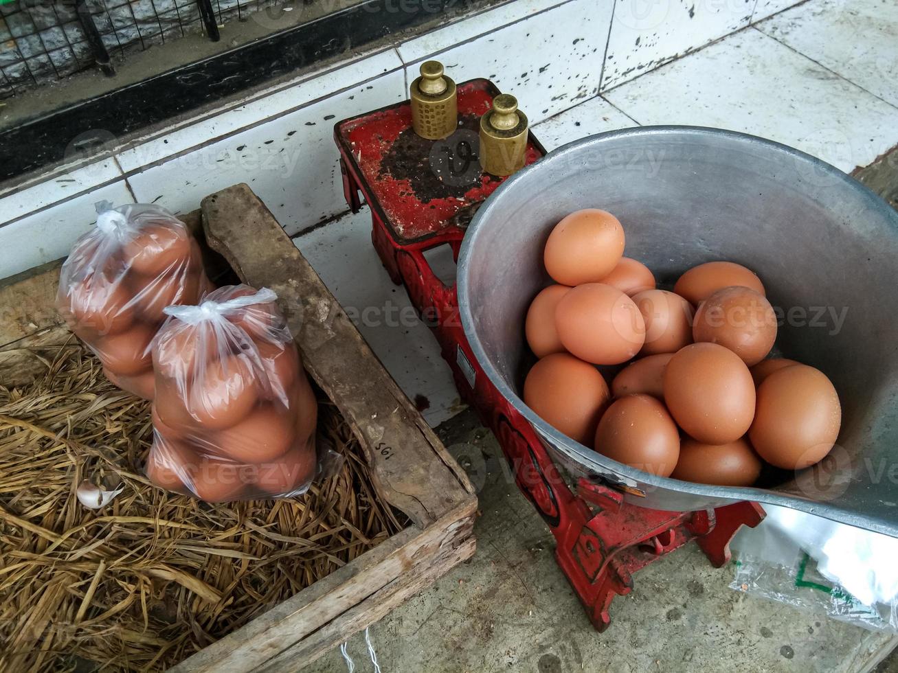 los huevos de gallina se pesan para estar listos para envasar en bolsas de plástico, en los mercados tradicionales indonesios foto