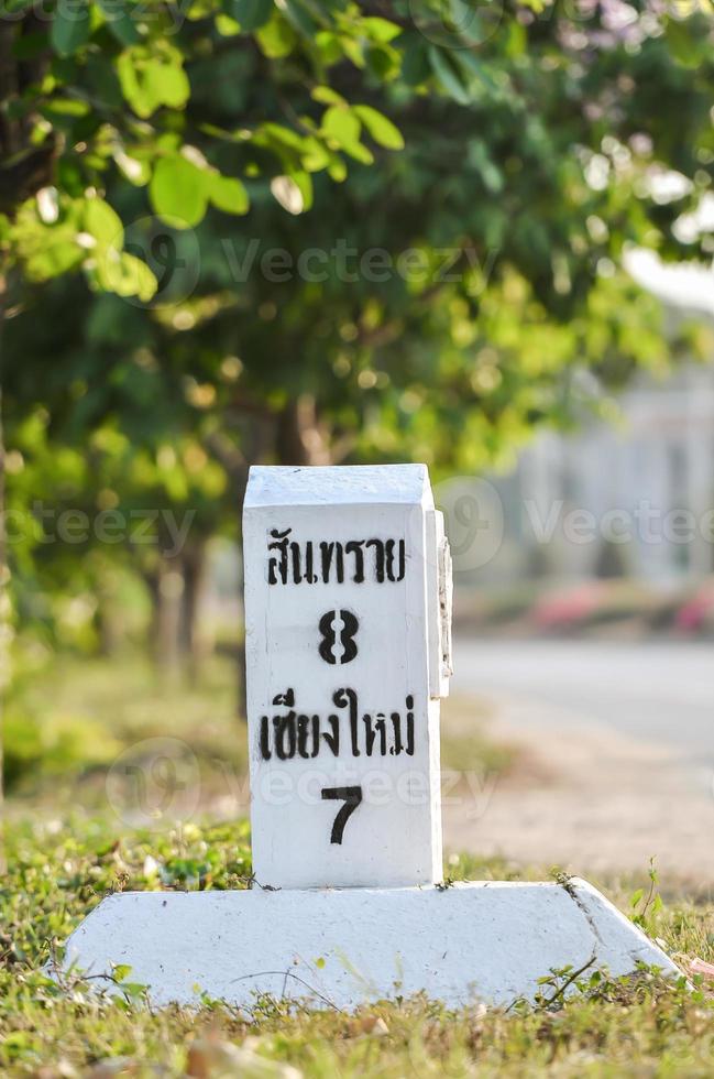 Distance marker post at road side photo