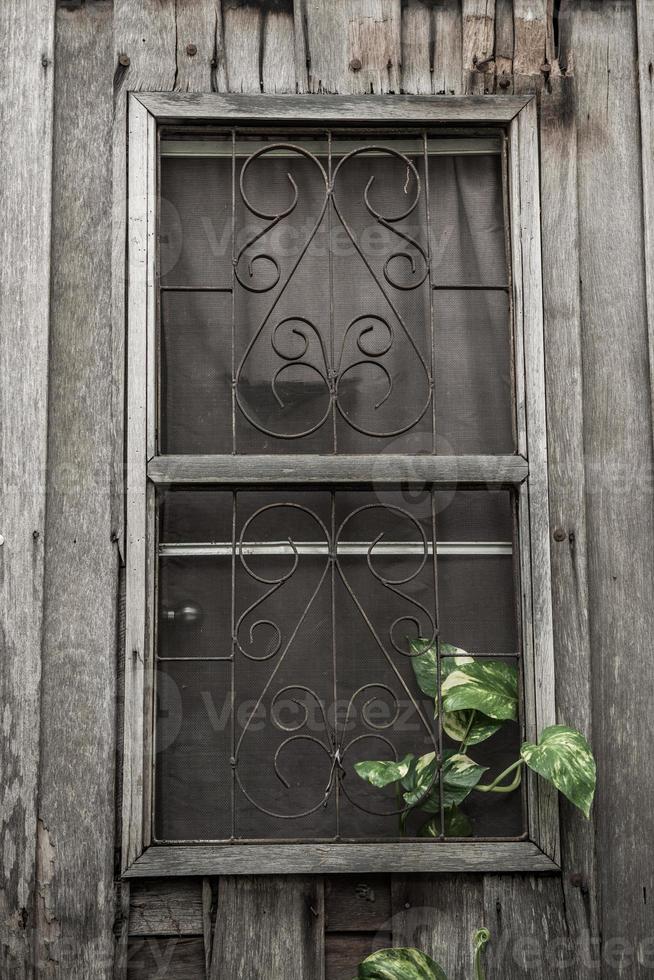 old house , window with wire screen and rack photo