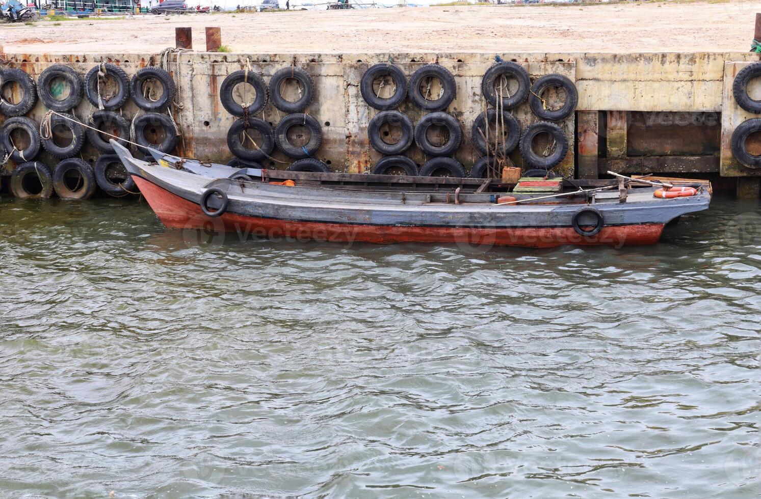 A small wooden fishing boat docking at the harbor. photo