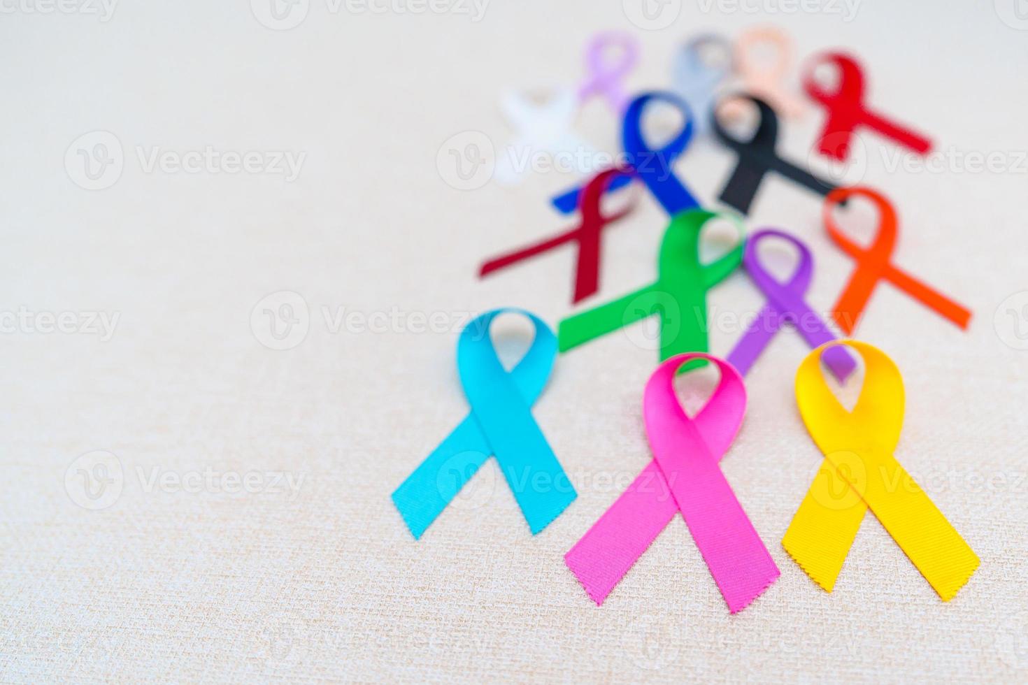 día mundial contra el cáncer, 4 de febrero. cintas de colores para apoyar a las personas que viven y están enfermas. cuidado de la salud, lucha, día médico y nacional de supervivencia del cáncer, concepto del día de concientización sobre el autismo foto