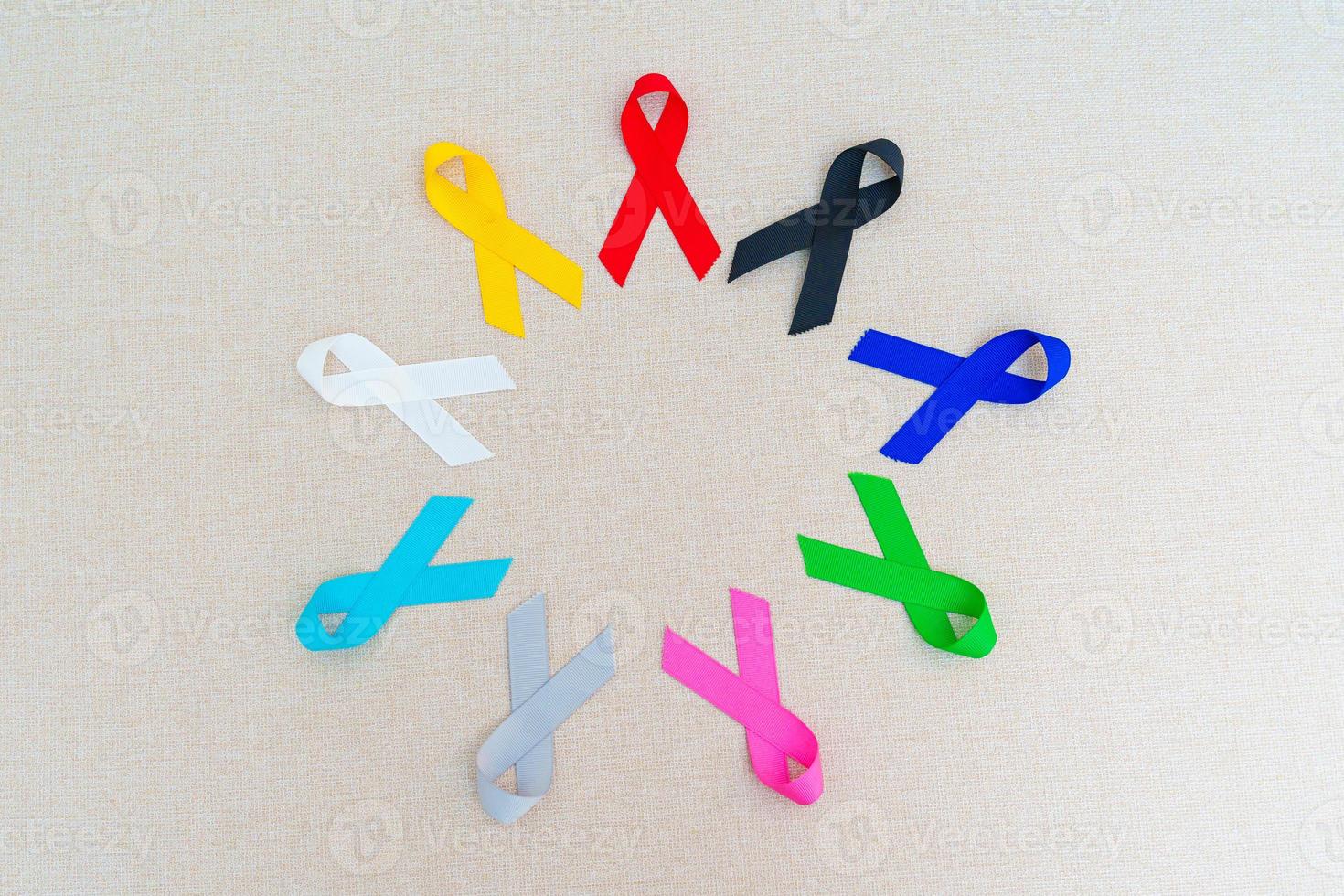 día mundial contra el cáncer, 4 de febrero. cintas de colores para apoyar a las personas que viven y están enfermas. cuidado de la salud, lucha, día médico y nacional de supervivencia del cáncer, concepto del día de concientización sobre el autismo foto