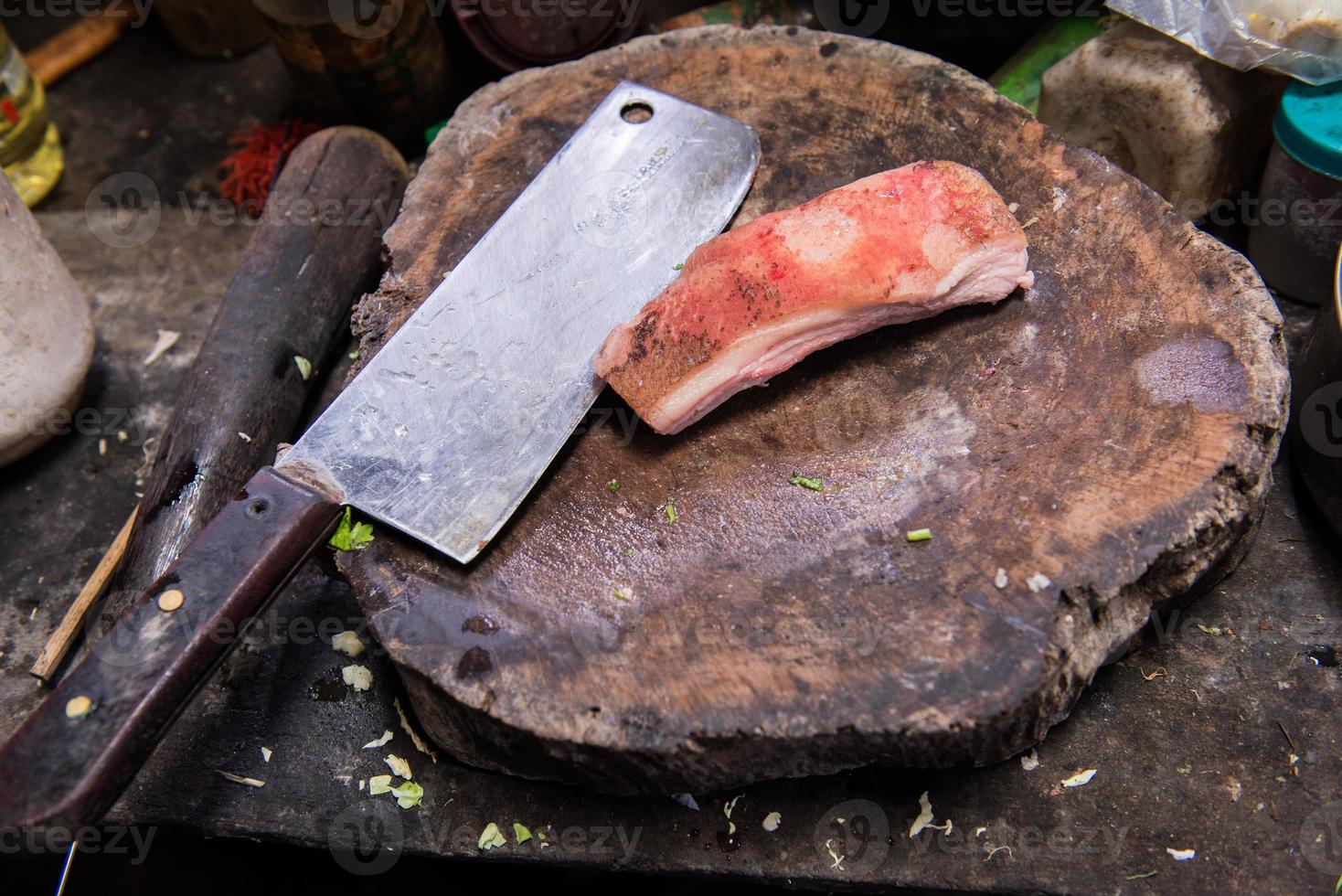 large old  knife on chopping block with meat photo