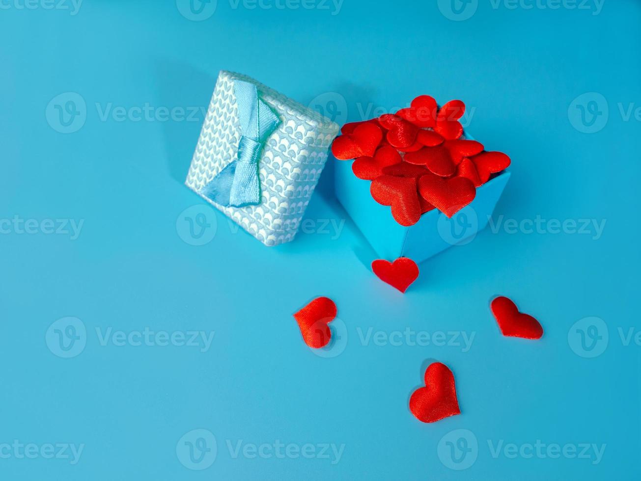 A gift for Valentine's day, Birthday or Christmas. Box with hearts on a blue background The concept of Valentine's day photo