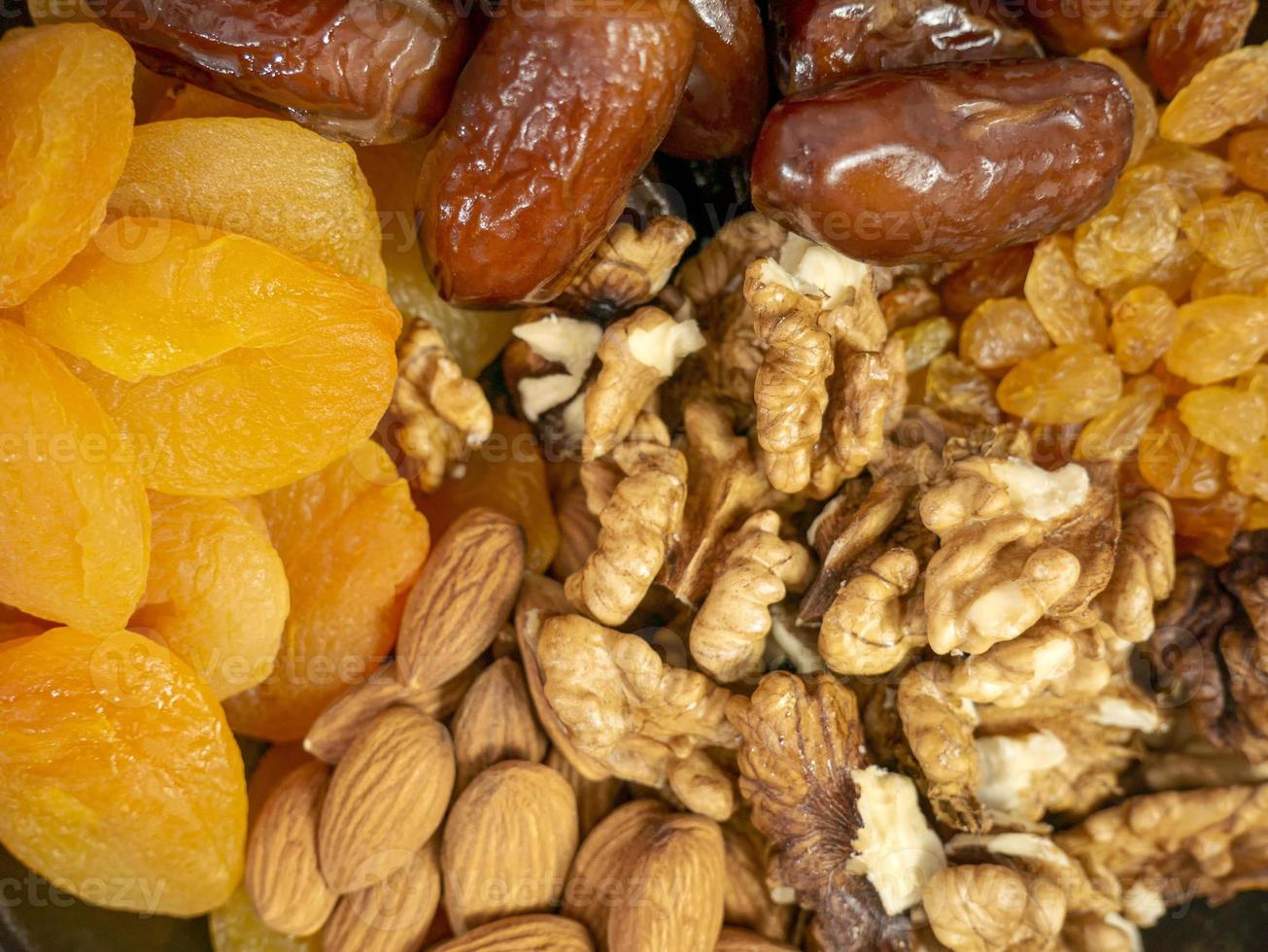 Nuts and dried fruits. Walnuts, almonds, dried apricots, raisins and dates. Healthy food and snacks. Oriental sweets photo