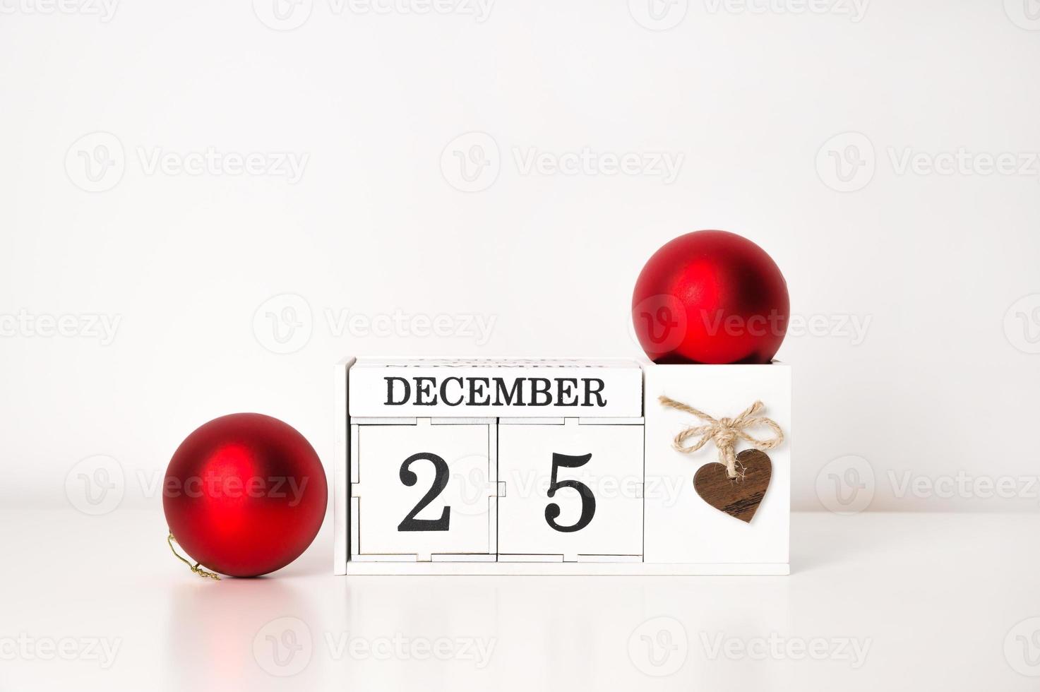 Calendar with date of December 25 and red Christmas balls near. Banner with place for text photo