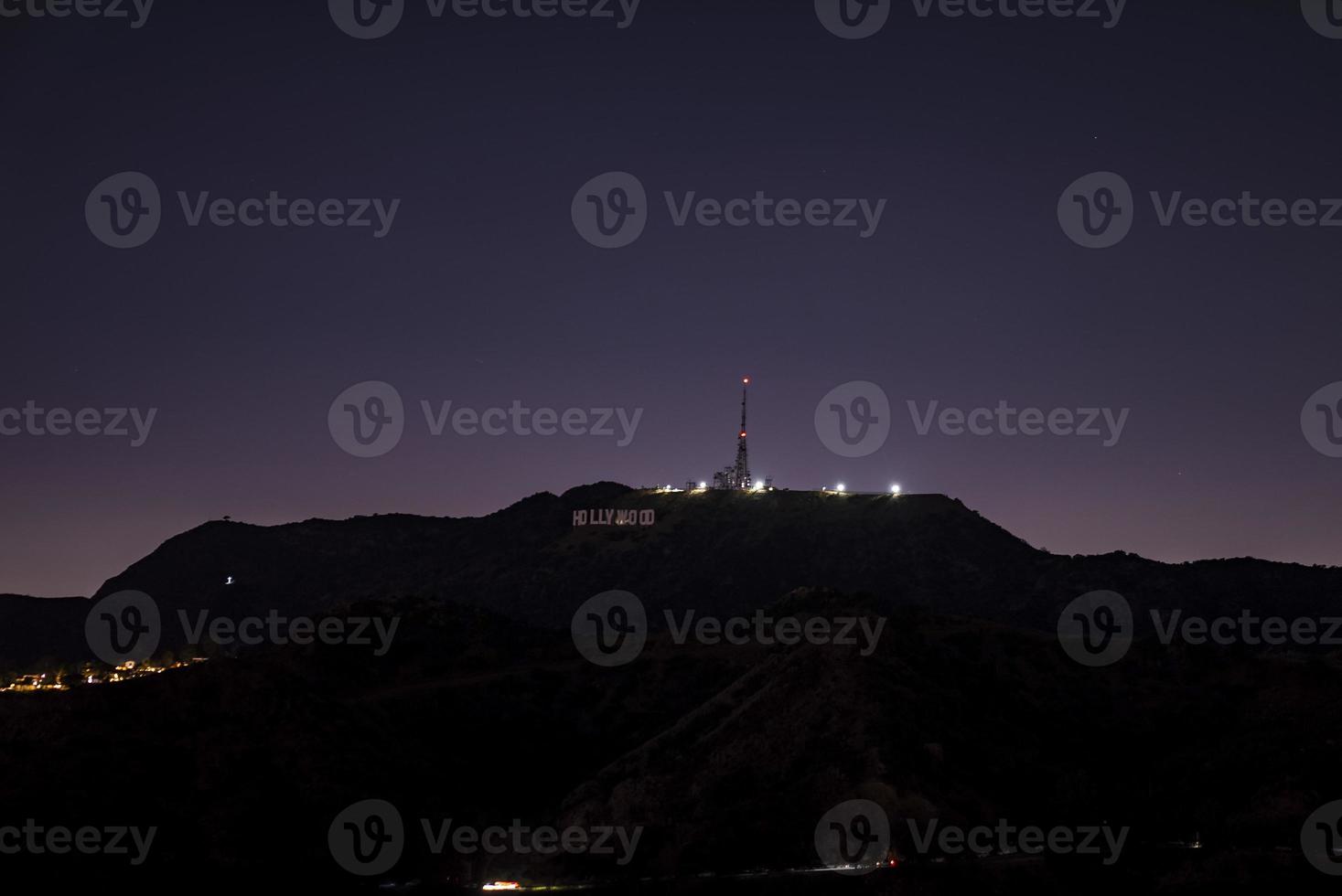 Hollywood sign with illuminated electricity pylon on Mount Lee at nighttime photo