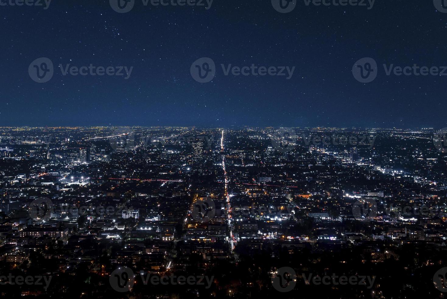 Drone shot of illuminated cityscape and beautiful stars shining in dark sky photo