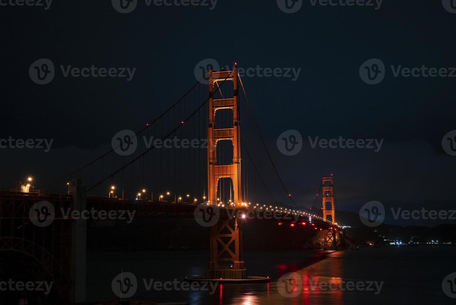 Illuminated Golden Gate Bridge over San Francisco Bay at night photo