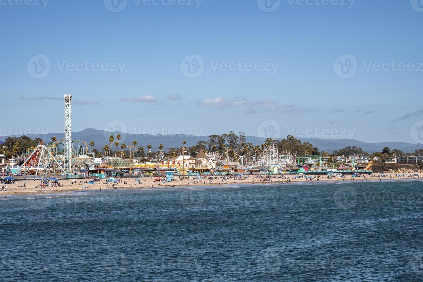 Distant view of amusement park rides and Santa Cruz Beach in front of ocean photo