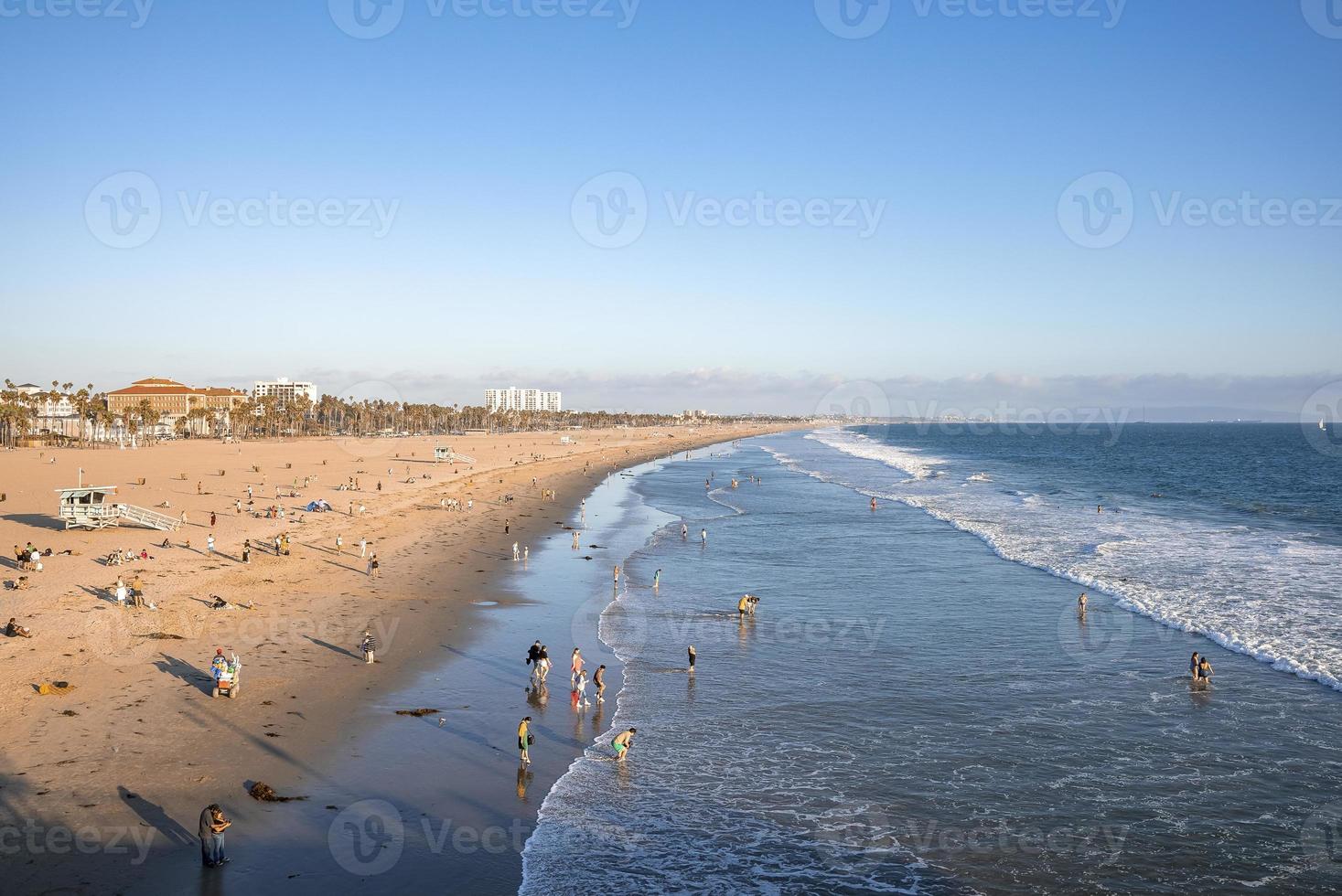 vista aérea de personas disfrutando en la playa de Venecia y olas salpicando en el mar foto