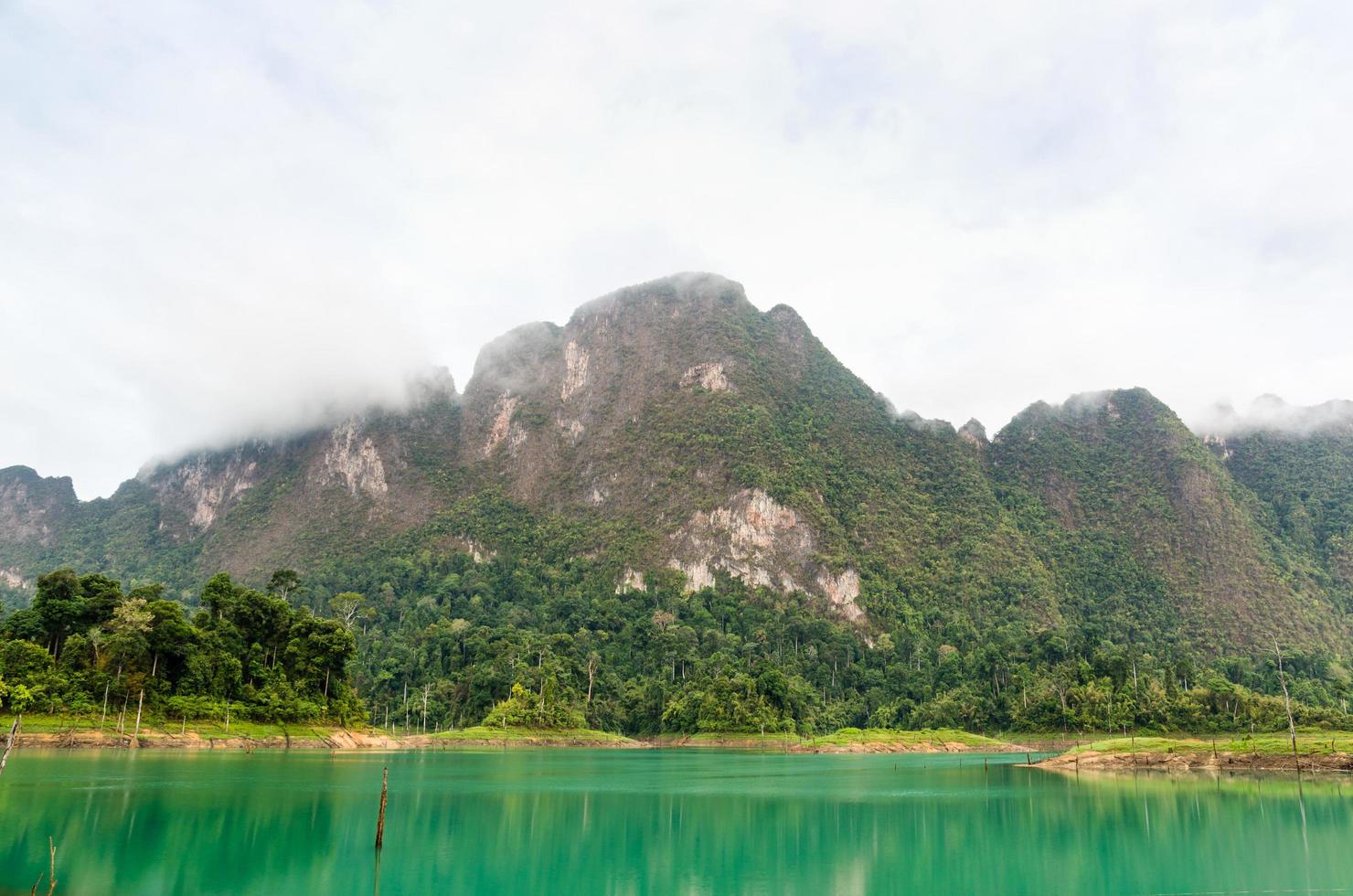 hermosas montañas altas y lago verde foto