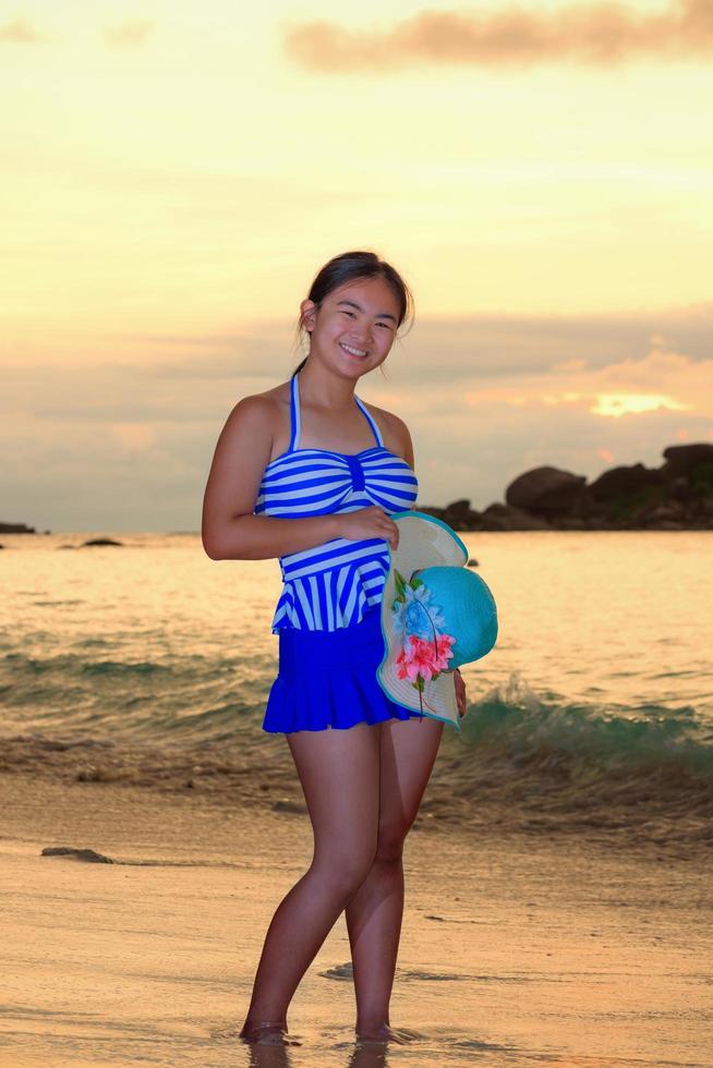 Girl on the beach at sunrise over the sea photo