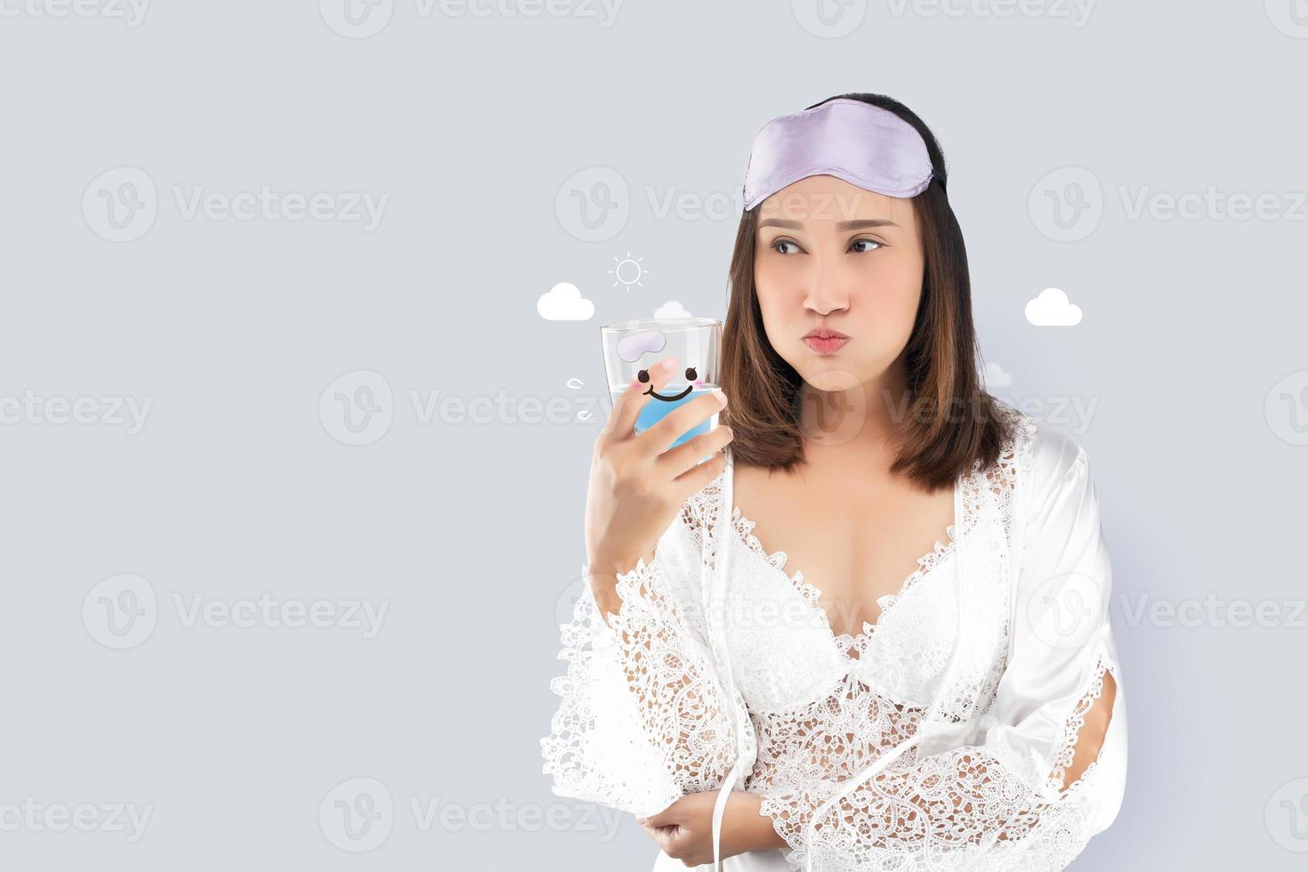 A woman in a white nightgown gargles. photo