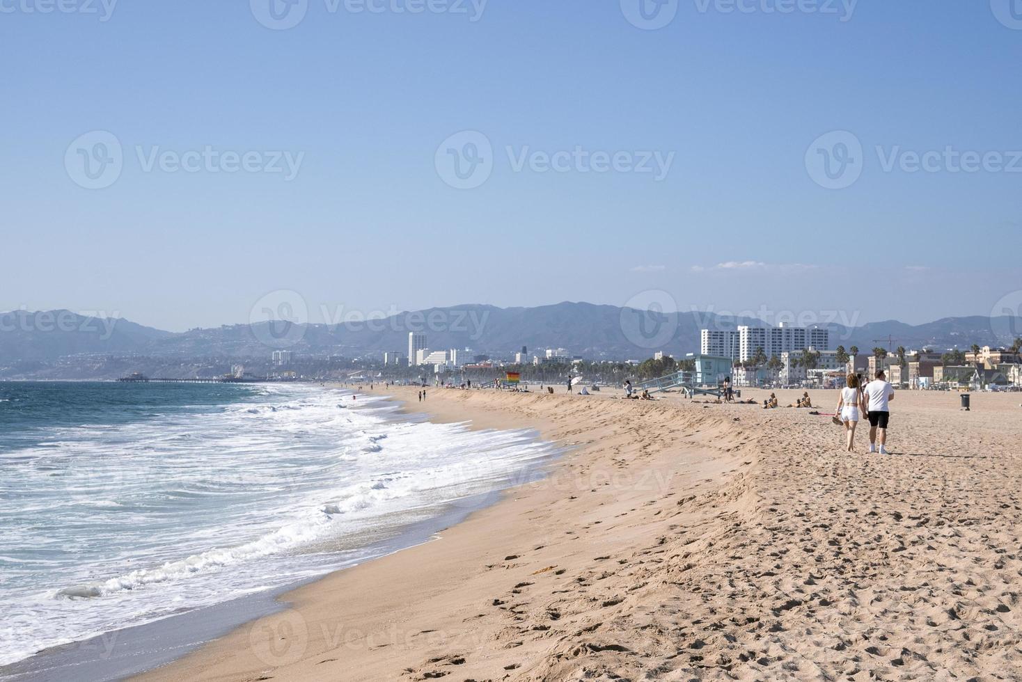 Scenic view of waves splashing on sandy beach at Los Angeles on sunny day photo