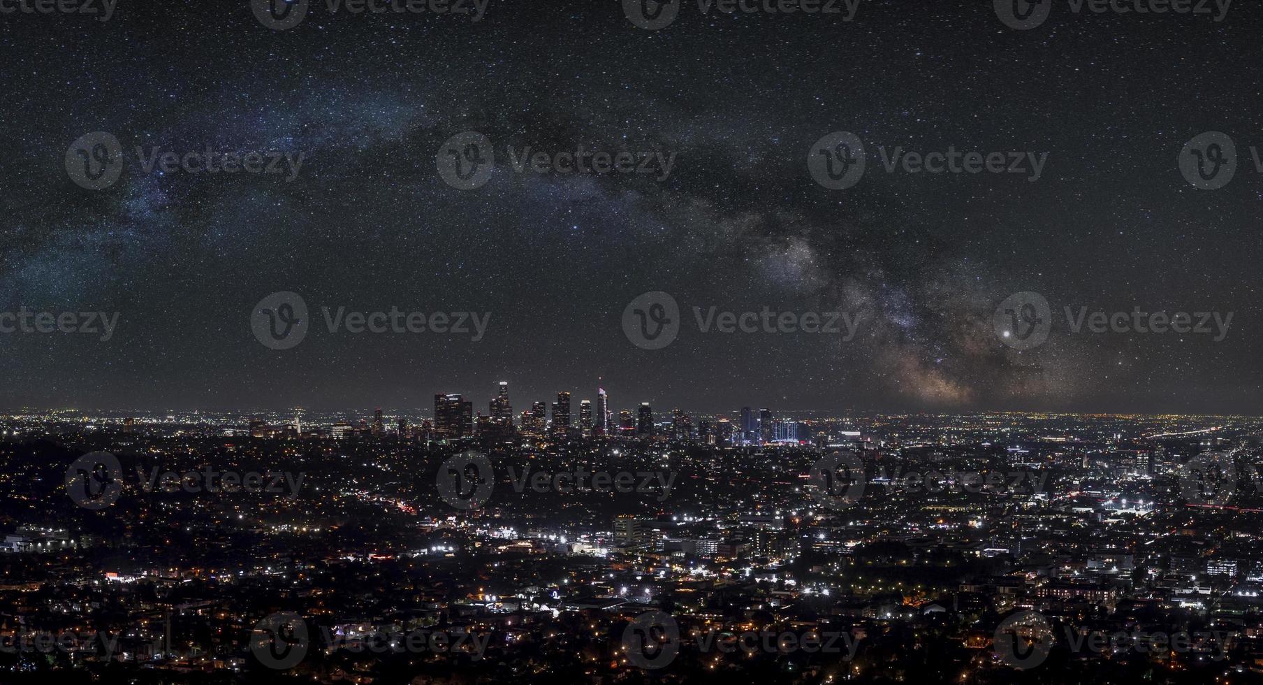 Aerial view of modern illuminated cityscape with beautiful stars shining in sky photo