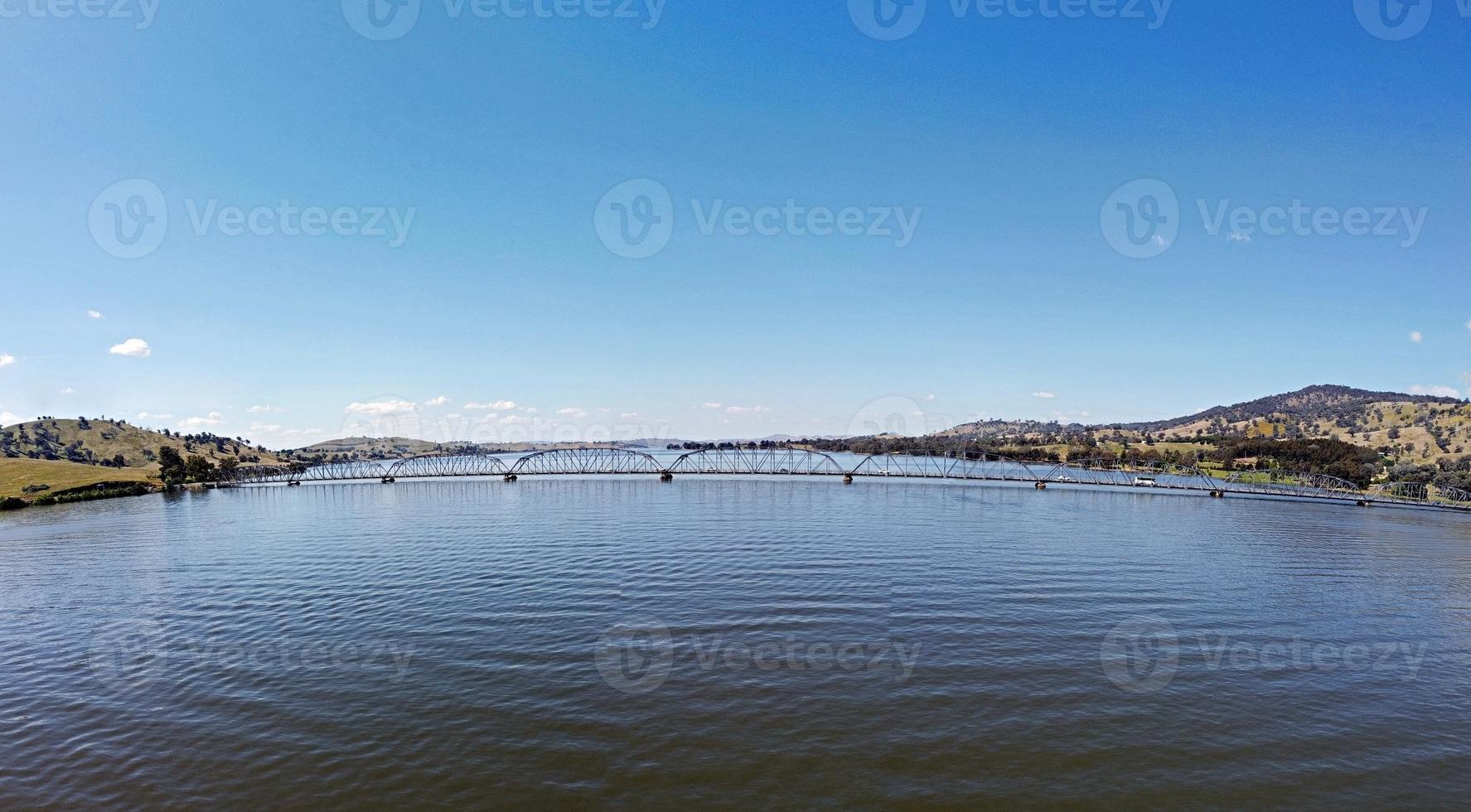 The panoramic view of Bethanga Bridge is a steel truss road bridge that carries the Riverina Highway across Lake Hume, an artificial lake on the Murray River in Australia. Image by drone flying. photo