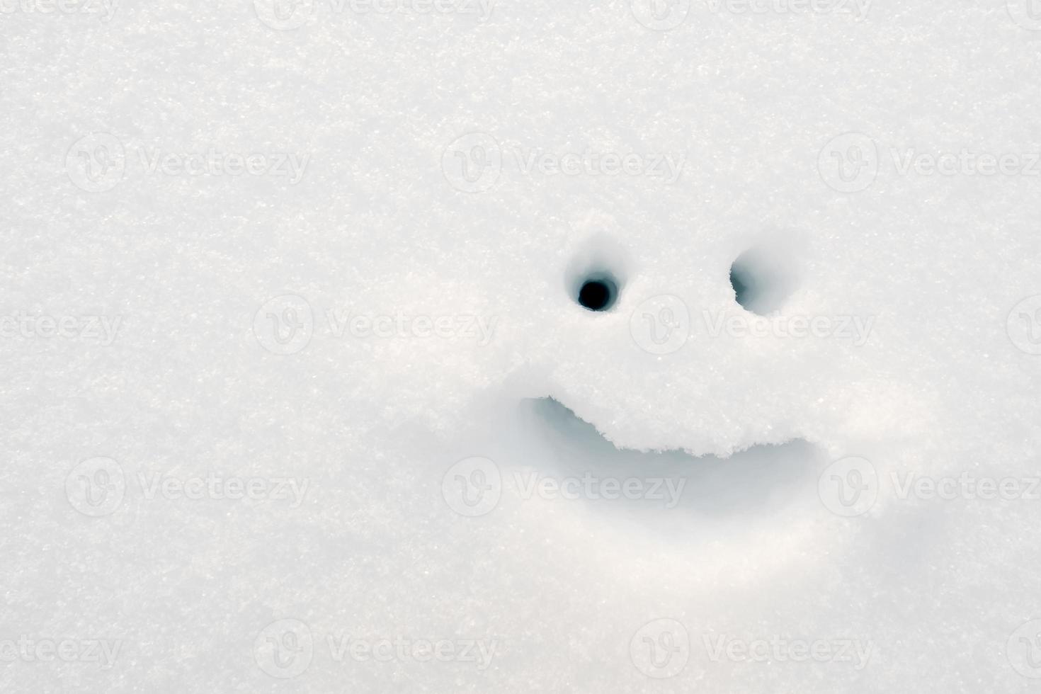 Smiley painted on the snow on a winter day. Copy space. Top view. photo