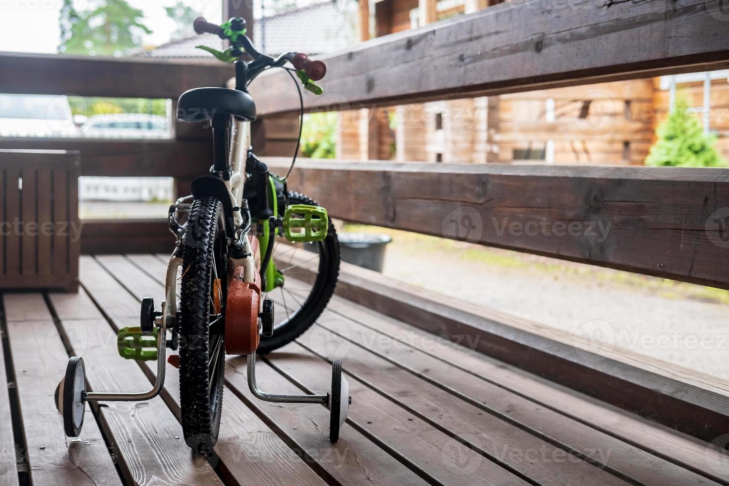 Bicycle child is parked on the porch of the house, in a small provincial town. photo