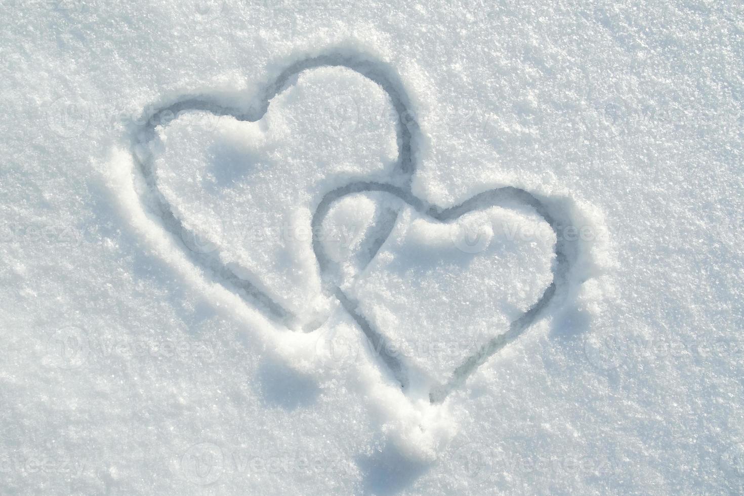 The symbol of two hearts drawn on the snow, on a sunny winter day. Romance. Valentine's Day. Copy space. photo