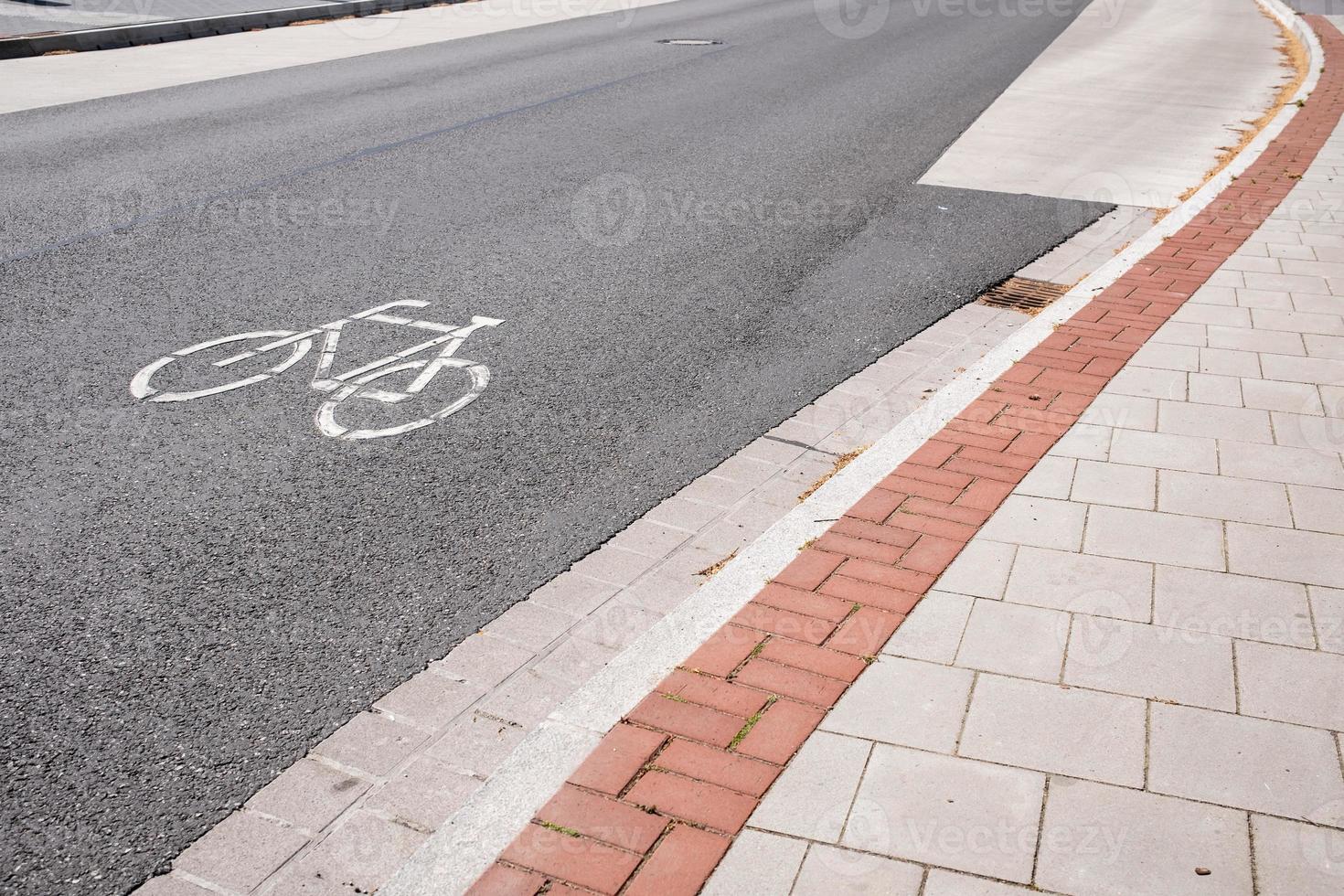 cartel impreso en la calzada que permite ir en bicicleta, junto a la acera. concepto de seguridad. foto