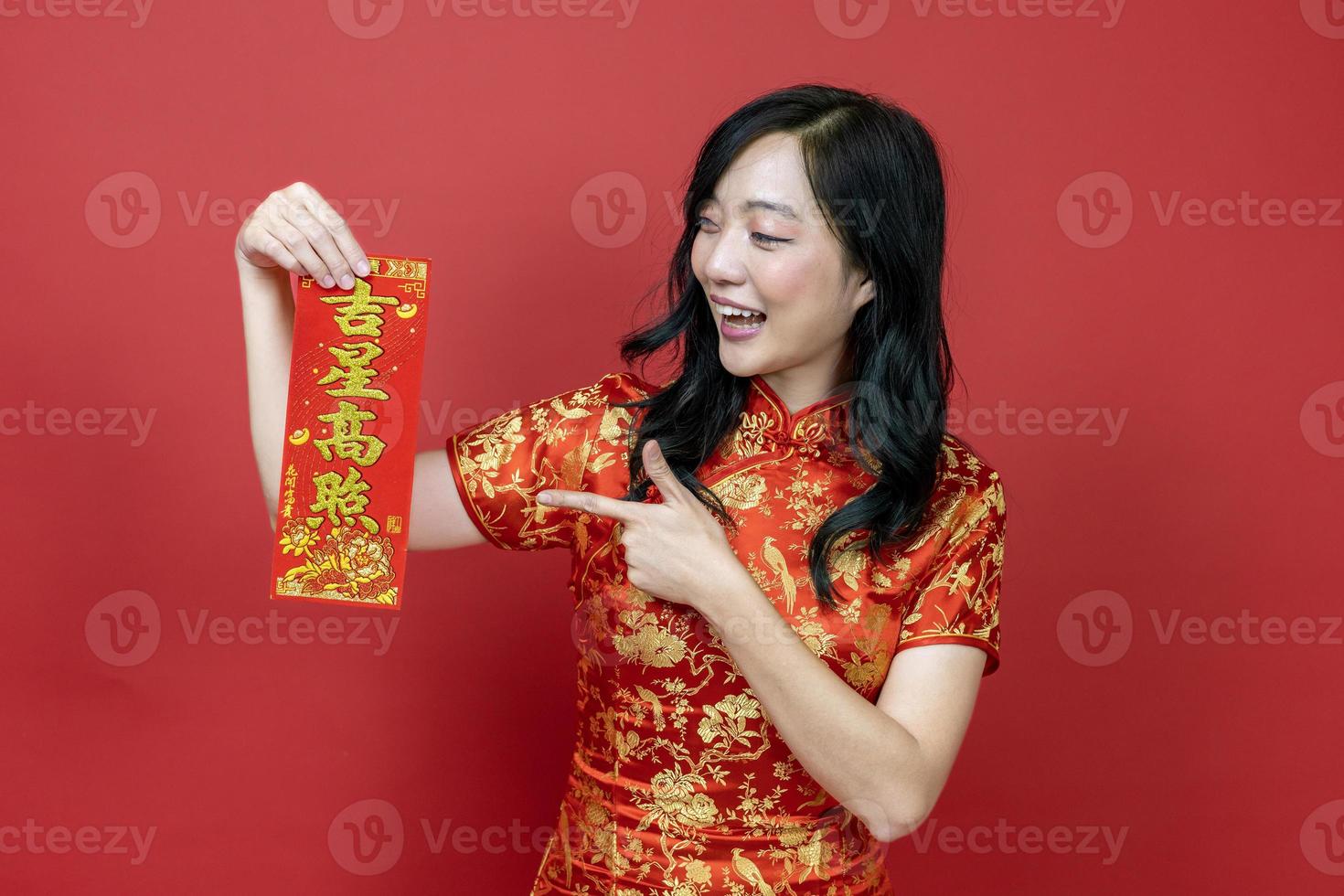 Asian woman holding red fortune blessing Chinese word which means to be blessed by a lucky star isolated on red background for Chinese New Year celebration concept photo